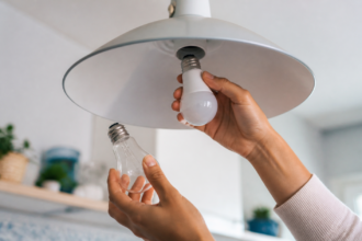 يد تستبدل مصباحًا تقليديًا بمصباح LED موفر للطاقة